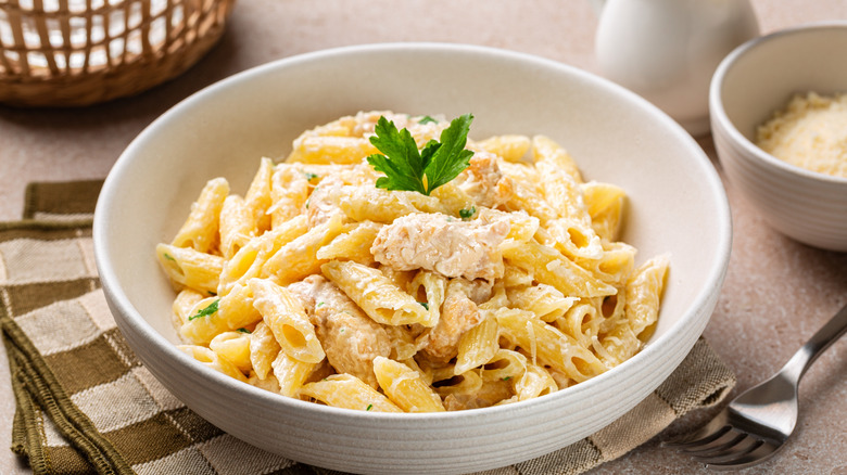 creamy chicken alfredo pasta in a white bowl