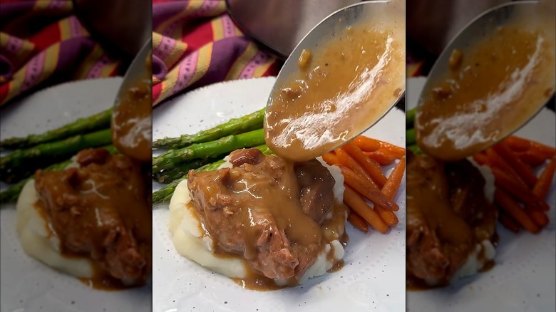 Spooning slow cooker beef tips and gravy over mashed potatoes