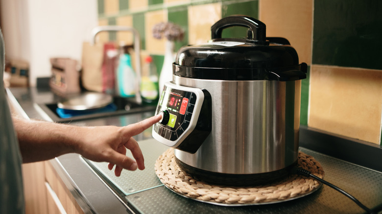Person programming a slow cooker