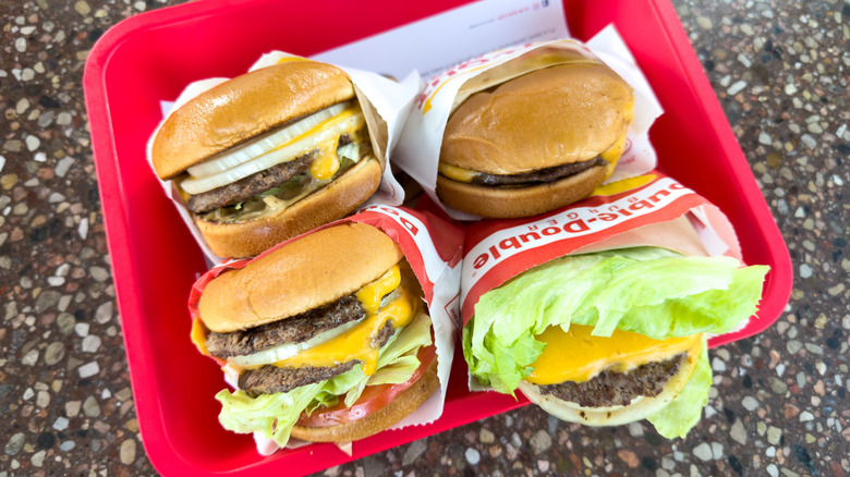 Four In-N-Out burgers on a red tray