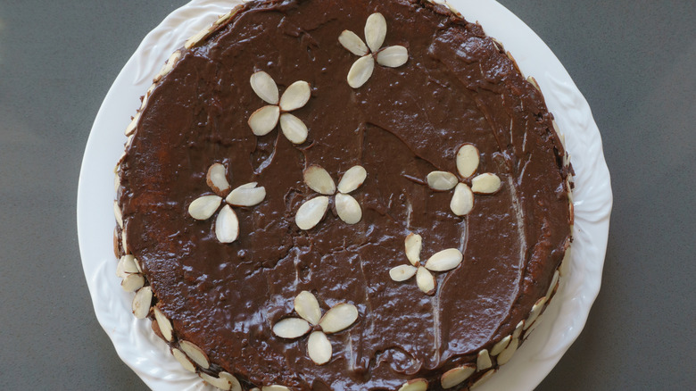 Top view of reine de saba cake with flower formations made of sliced almonds