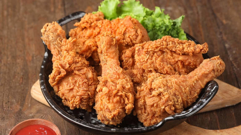 A pile of fried chicken drumsticks on a plate
