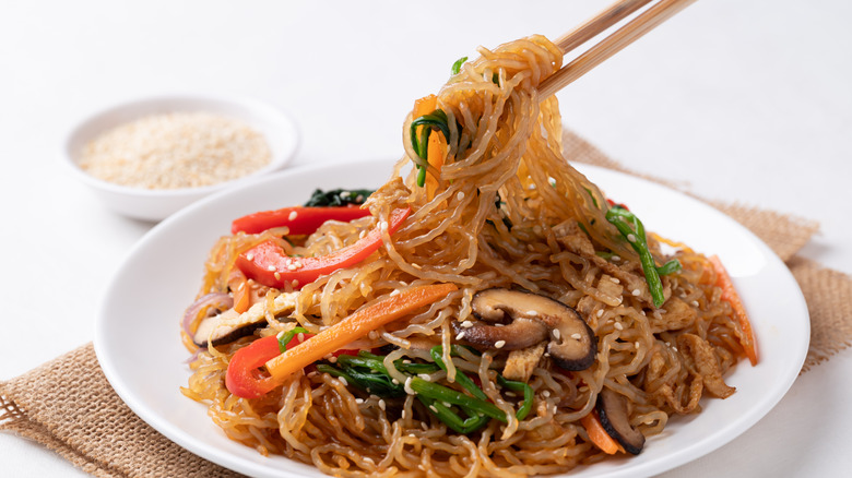 chopsticks lifting up some vegetable japchae