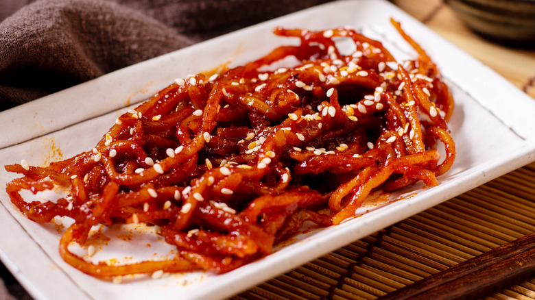 a plate of ojingeochae muchim topped with sesame seeds