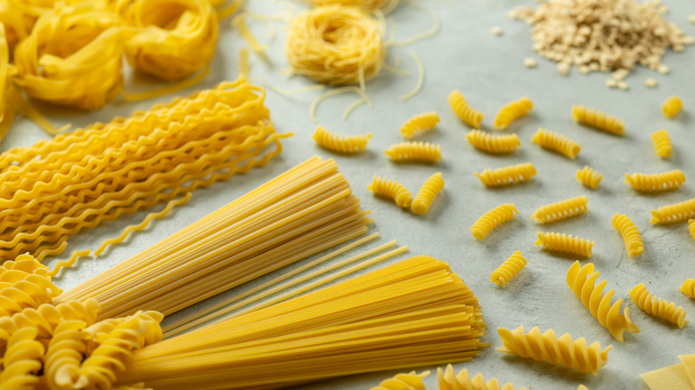 various pasta shapes on a grey table