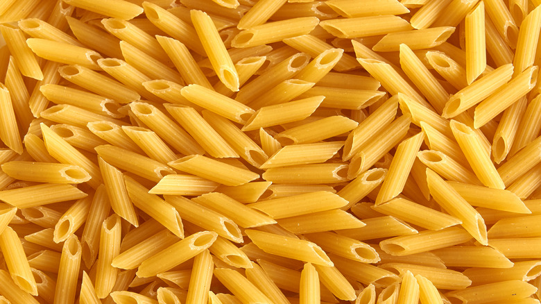 An overhead view of penne pasta in a pile