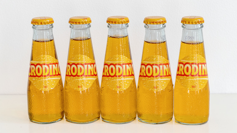 Five bottles of Crodino lined up with a white background