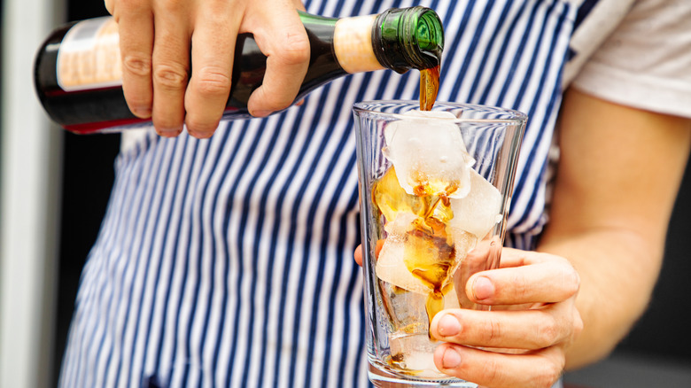 A man pouring Fernet-Branca into a glass with ice