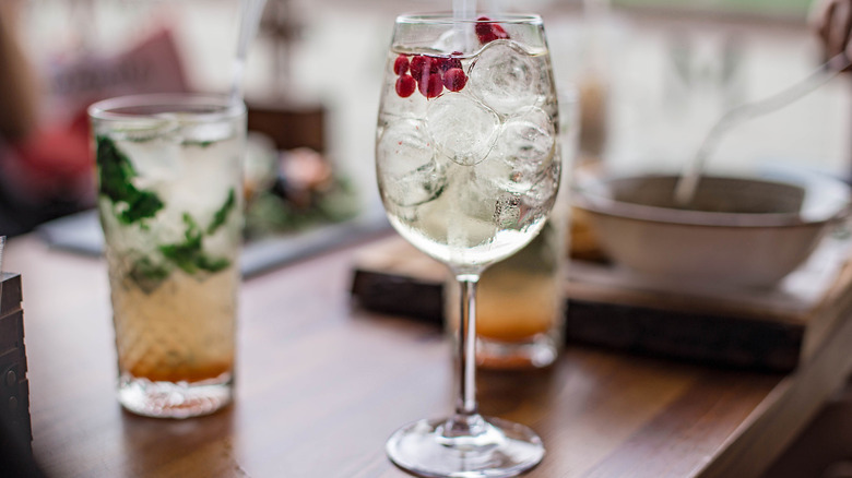 A Lillet spritz with cranberries next two other cocktails.