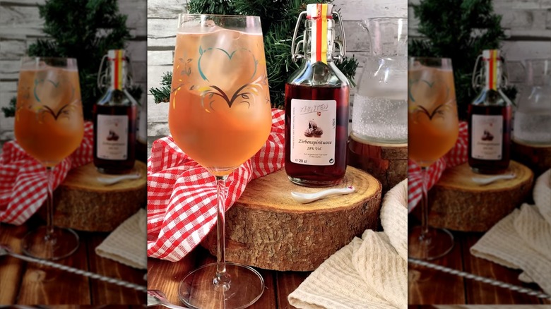 Someone pouring Prosecco over a Zirbenz spritz