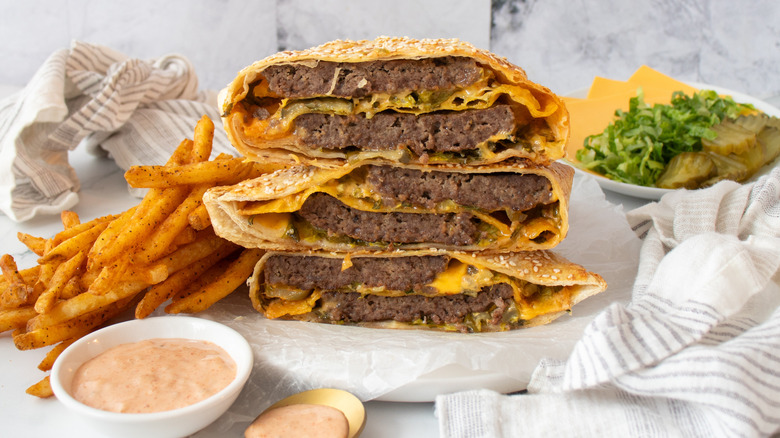 two halved smash burger crunch wraps with fries