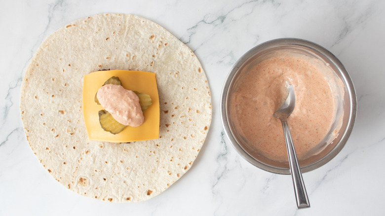 smash burger and toppings on tortilla