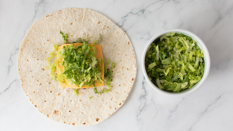 smash burger and toppings on tortilla