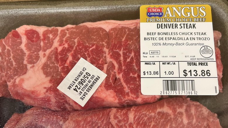 Two raw Denver steaks in grocery store packaging
