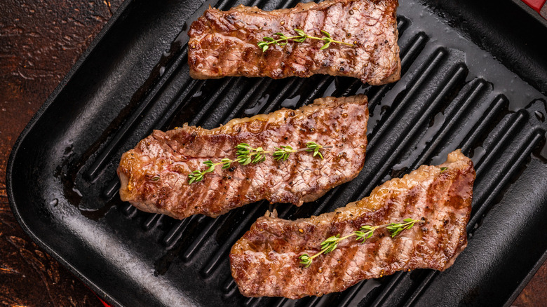 Grilled tri-tip steaks garnished with thyme