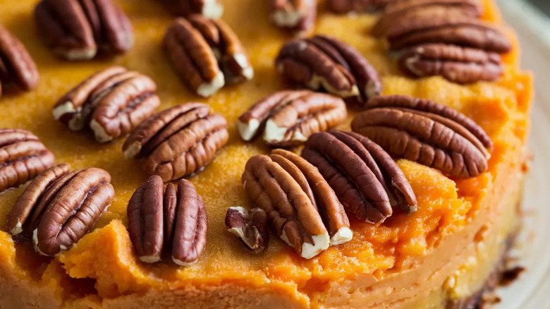A sweet potato pie topped with crispy pecans.