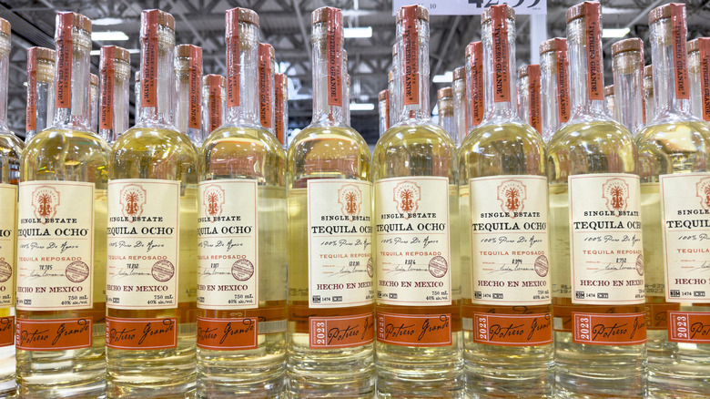 Bottles of Tequila Ocho reposado lined up on a shelf