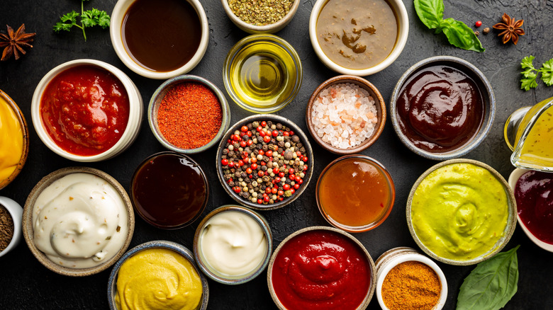 Various dipping sauces in bowls on a black table