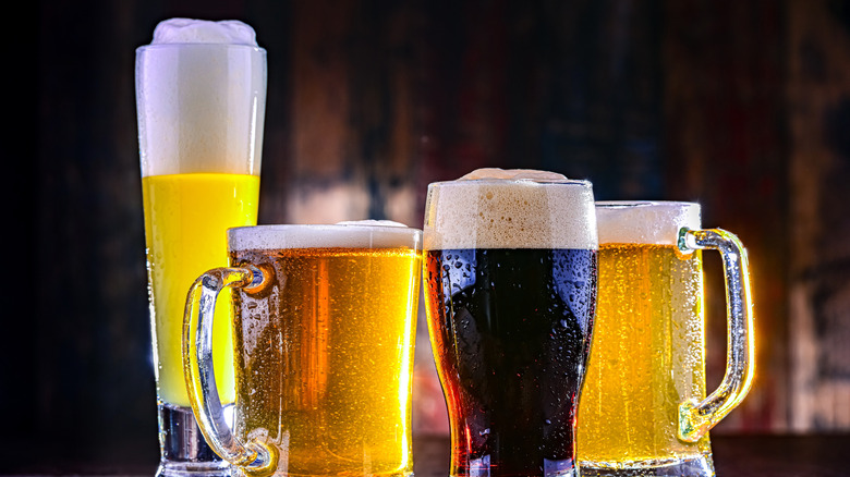 Four glasses filled with different types of beer