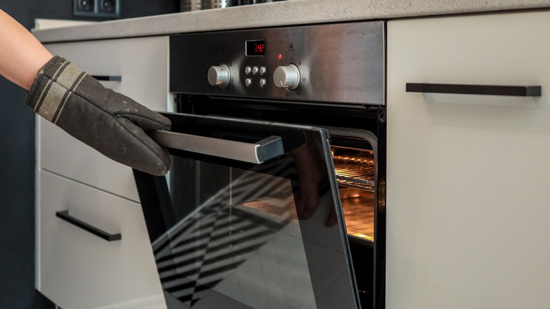 Hand opening an oven