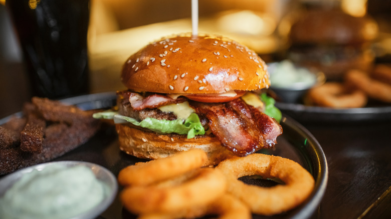 Burger on plate with onion rings and sauce