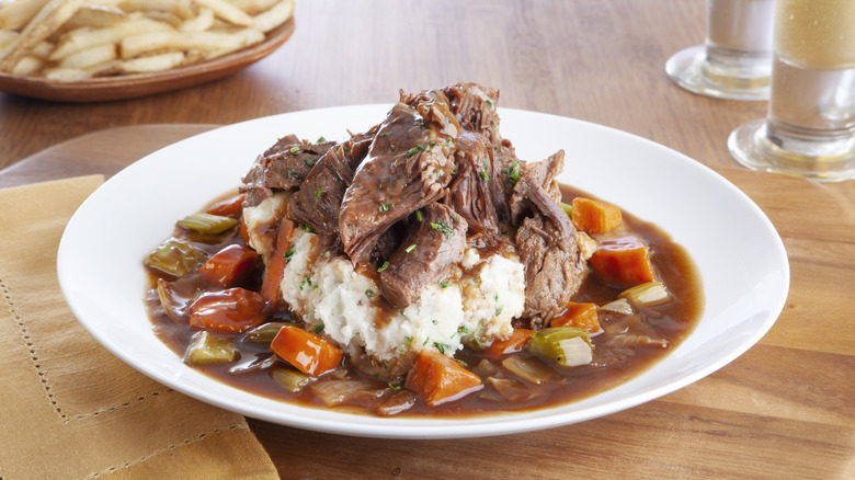 Pot roast on mashed potatoes in a plate