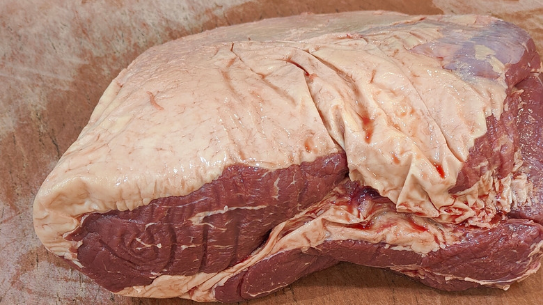 Raw top sirloin butt steak on paper