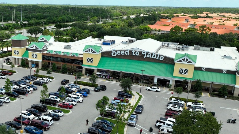 Green roofed grocery store with white sign that reads "Seed to Table"