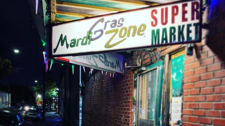 White illuminated sign that reads "Mari Gras Zone Super Market"