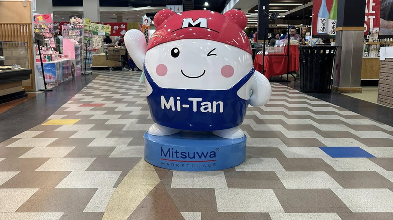 Cute cartoon caracter in apron waving and winking in Mitsuwa grocery store