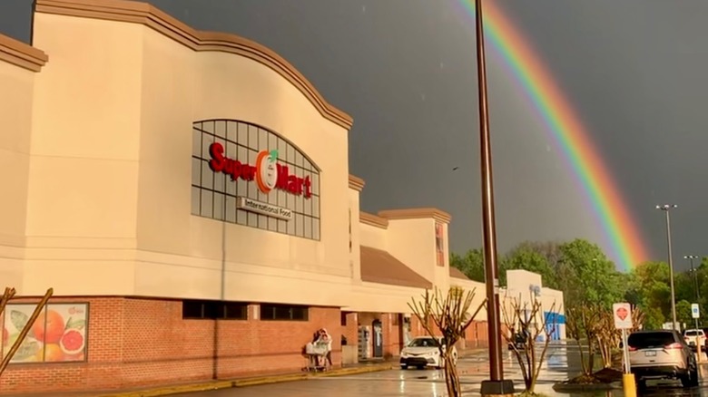 Exterior of Super G Mart with a rainbow in the sky above