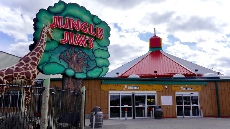 Giraffe statue and giant tree-shaped sign that reads "Jungle Jim's"