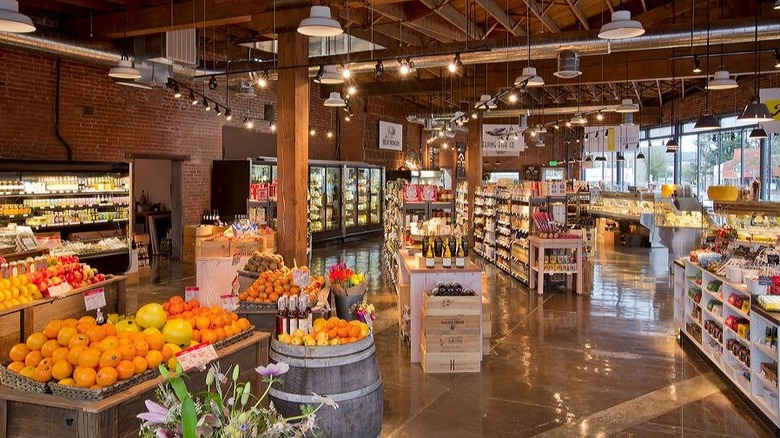 Grocery store interior with exposed wooden beams and bright lighting