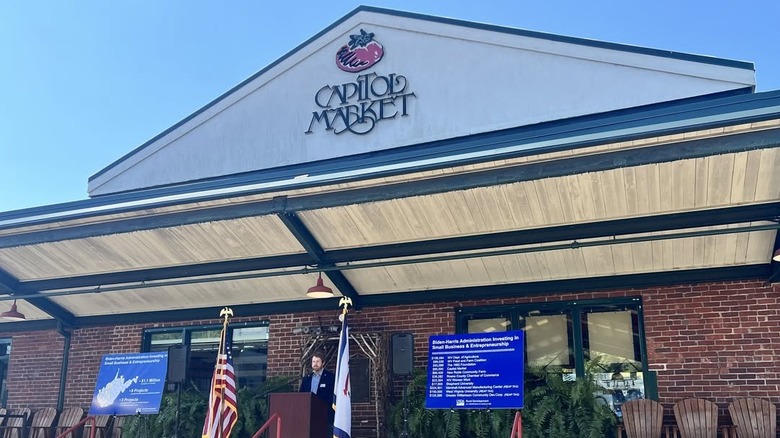 Man speaking in front of entrance to Capitol Market