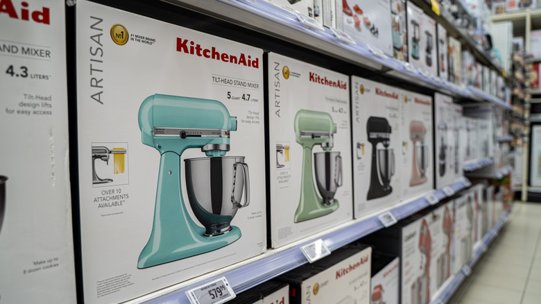Boxes of KitchenAid stand mixers line a store shelf.
