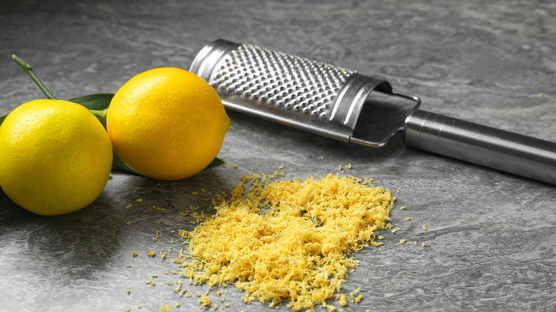 Lemon zest on gray surface with microplane