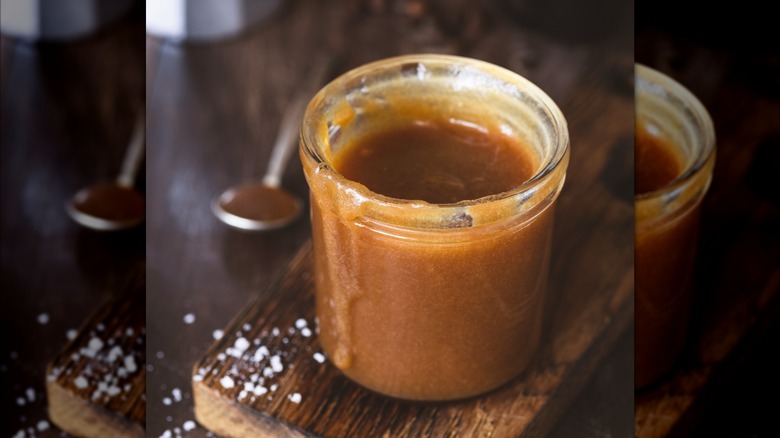 Caramel sauce in a jar with a spoon