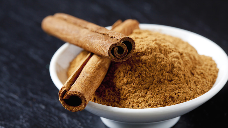 Cinnamon in a bowl with cinnamon sticks