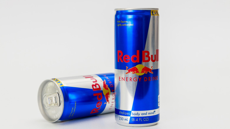Two cans of Red Bull on a whitish-gray background