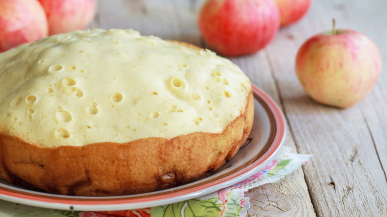 Slow cooker apple cake with dappled frosting on a plate