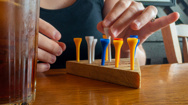 Woman playing Cracker Barrel peg game at table