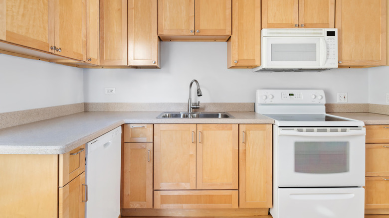 Outdated kitchen with white appliances