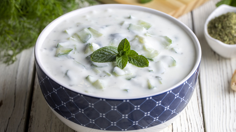 A bowl of tzatziki on a wooden table.