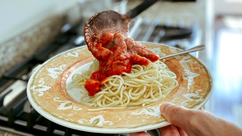 Pouring sauce on spaghetti