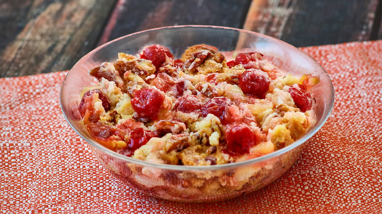 glass bowl with dump cake filled with fruit and nuts