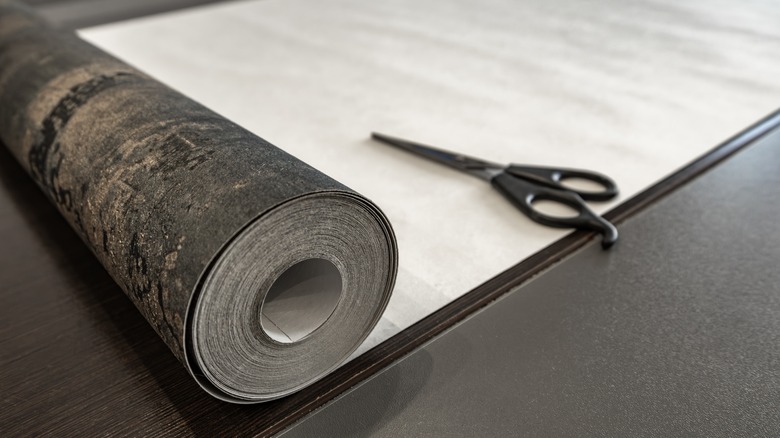 a roll of wallpaper with scissors