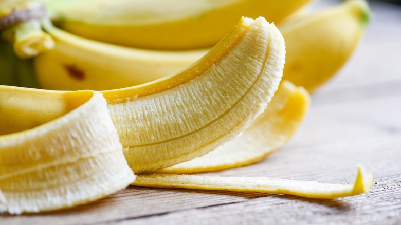 Half peeled banana on wood