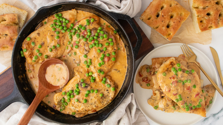Overhead shot of chicken a la king, plated and in skillet served with focaccia