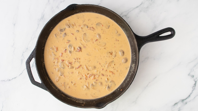 A composed, lightly brown cream sauce in a large skillet