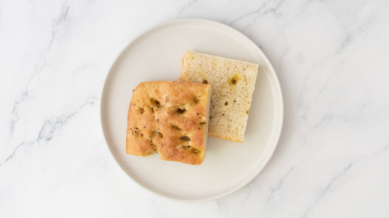 A portion of focaccia bread, halved, on a white plate